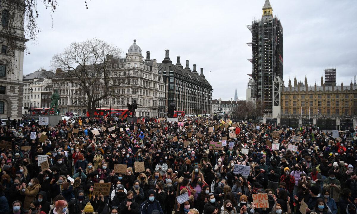 Protesters calling for greater public safety for women after the death of Sarah Everard, against the police handling of a gathering on Clapham Common in Sarah Everard's honour and against a proposed law that would give police more powers to intervene on protests hold placards as they gather in Parliament Square in central London on March 14, 2021. (Daniel Leal-Olivas/AFP via Getty Images)