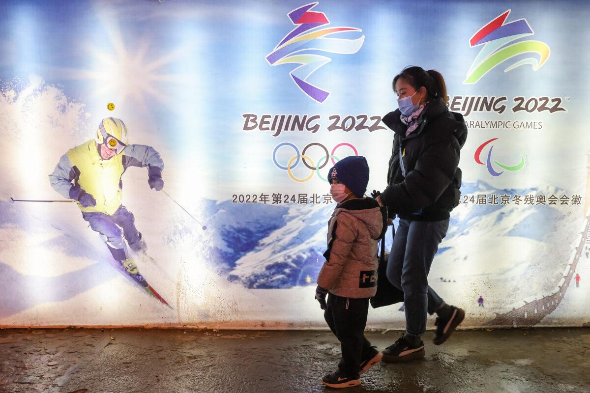 People walk in front of logos of the 2022 Beijing Winter Olympics at Yanqing Ice Festival in Beijing, on Feb. 26, 2021. (Lintao Zhang/Getty Images)