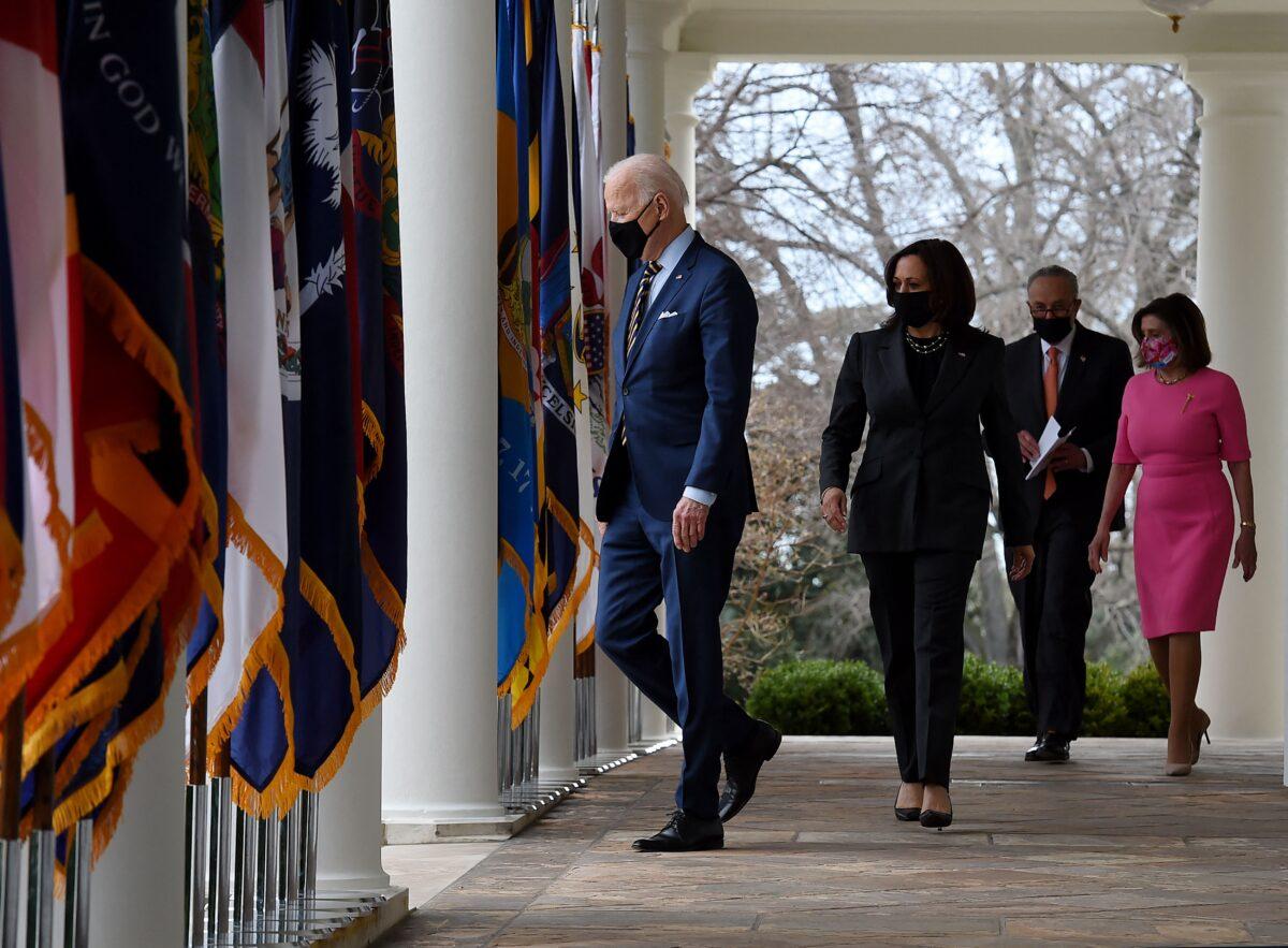 President Joe Biden, with (L-R) Vice President Kamala Harris, Senate Majority Leader Chuck Schumer (D-N.Y.), and House Speaker Nancy Pelosi (D-Calif.), arrives to speak about the American Rescue Plan in the Rose Garden of the White House in Washington on March 12, 2021. (Olivier Douliery/AFP via Getty Images)