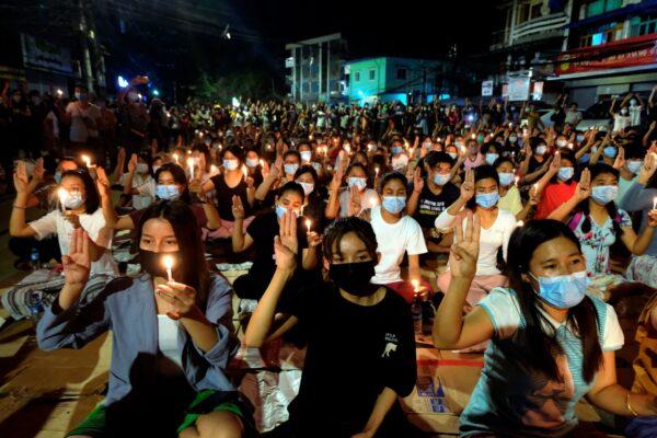 Anti-coup protesters flash the three-fingered salute during a candlelight night rally in Yangon, Burma, on March 14, 2021. (AP Photo)