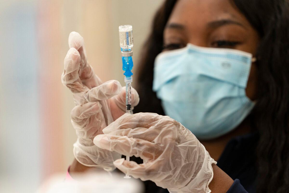  A health worker loads syringes with the vaccine on the first day of the Johnson & Johnson vaccine being made available to residents at the Baldwin Hills Crenshaw Plaza in Los Angeles, Calif., on March 11, 2021. (Damian Dovarganes/AP Photo)