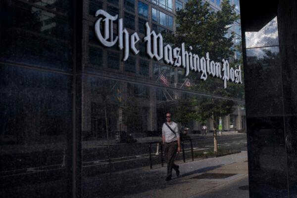 A man walks past The Washington Post in Washington on Aug. 5, 2013. (Brendan Smialowski/AFP via Getty Images)