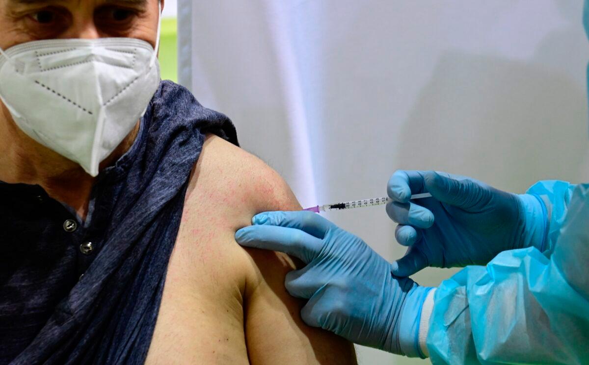 German police officer Dirk Moeller gets an AstraZeneca vaccination against the CCP virus at a new vaccination center at the former Tempelhof airport in Berlin on March 8, 2021. (Tobias Schwarz/Pool via AP)