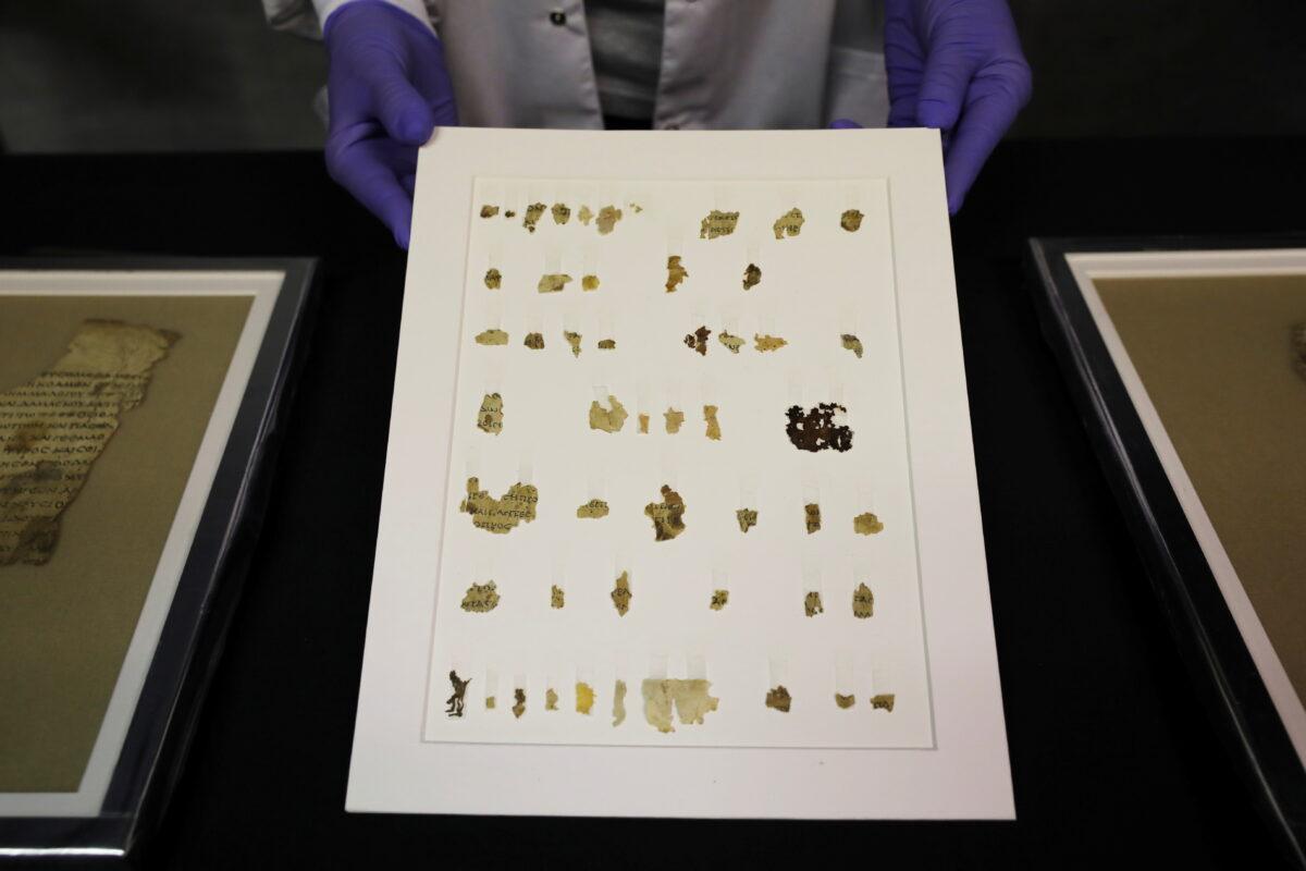 An employee shows recently-discovered scroll fragments of an ancient biblical text at Israel Antiquities Authority laboratories in Jerusalem, Israel, on March 16, 2021. (Ammar Awad/Reuters)