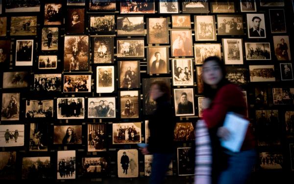 People walk past a wall of photos from the town of Eishyshok, Lithuania, where the Nazis first began to implement the "Final Solution," at the U.S. Holocaust Memorial Museum in Washington on Jan. 26, 2007. (Brendan Smialowski/Getty Images)