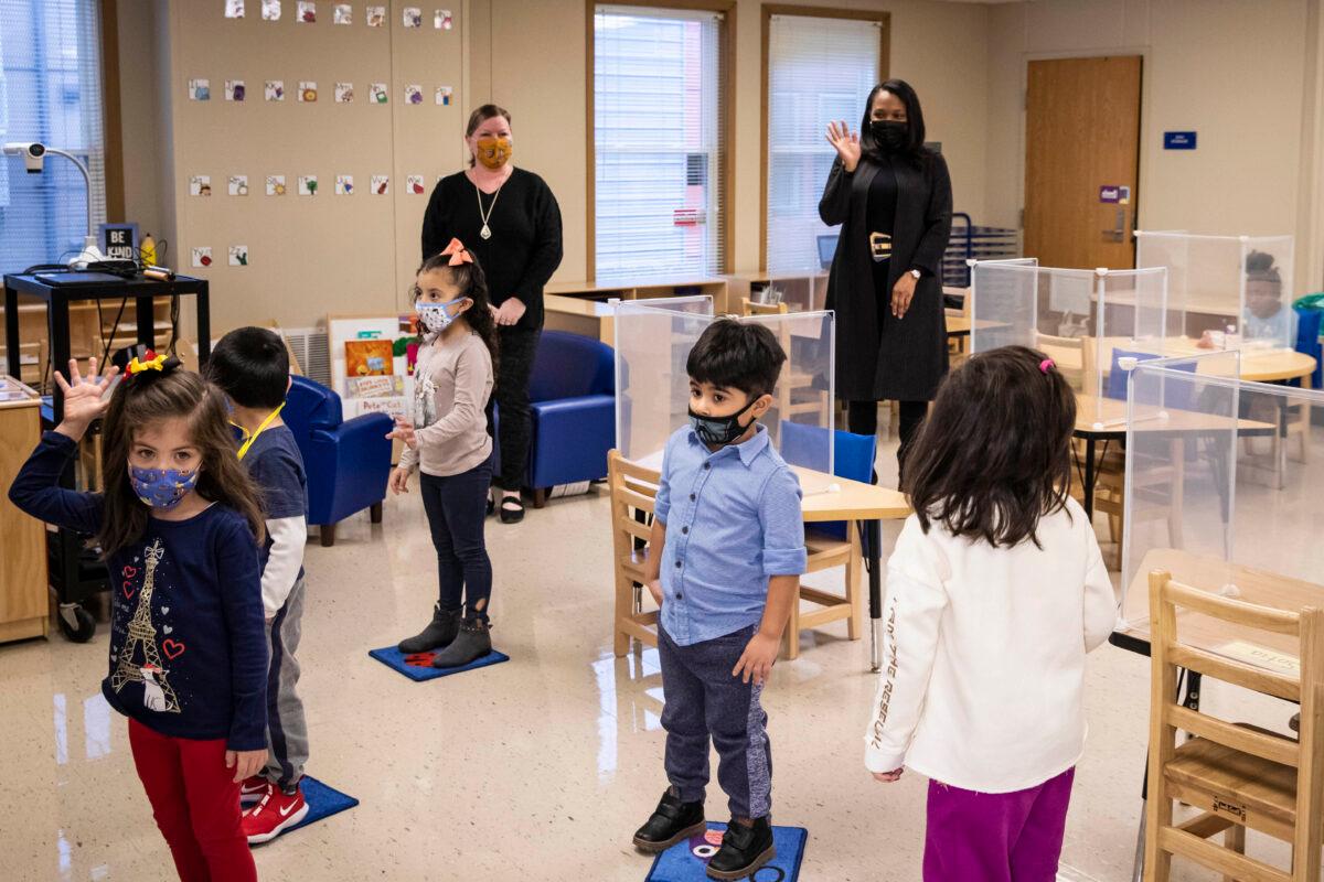 Chicago Public Schools CEO Janice Jackson, background right, waves to students in a preschool classroom at Dawes Elementary School in Chicago, on Jan. 11, 2021. (Ashlee Rezin Garcia/Chicago Sun-Times via AP)