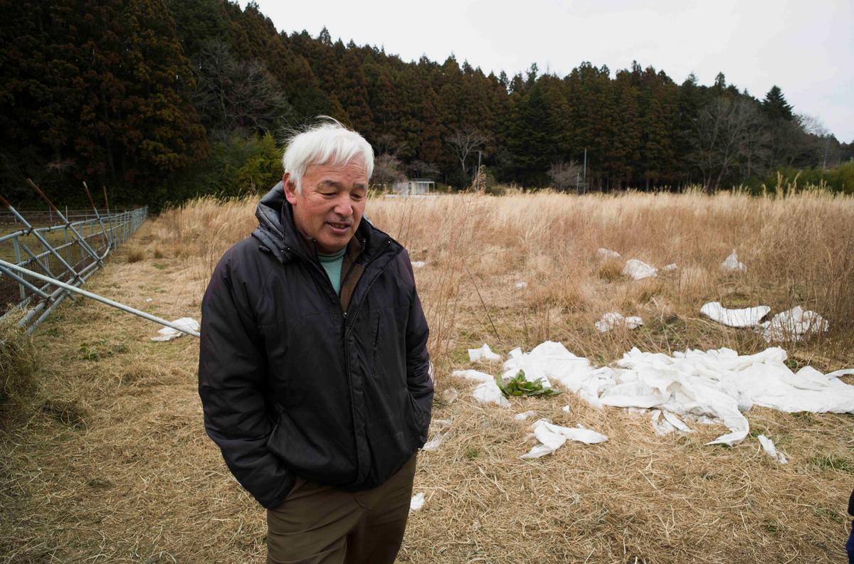 Naoto Matsumura speaks during an interview with The Associated Press at his farm land in Tomioka town, Fukushima prefecture, northeastern Japan, Friday, Feb. 26, 2021. About 10 kilometers (6 miles) south of the wrecked Fukushima Dai-ichi nuclear power plant, rice farmer Matsumura defied a government evacuation order and stayed on his farm to protect his land the cattle abandoned by neighbors a decade ago. (Hiro Komae/AP)