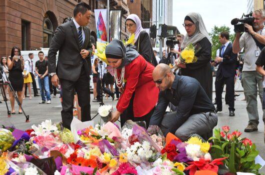 Representatives of the Muslim community lay flowers at a floral memorial at the scene of a dramatic siege that left two hostages dead, in Sydney on December 16, 2014 (William West/AFP via Getty Images)