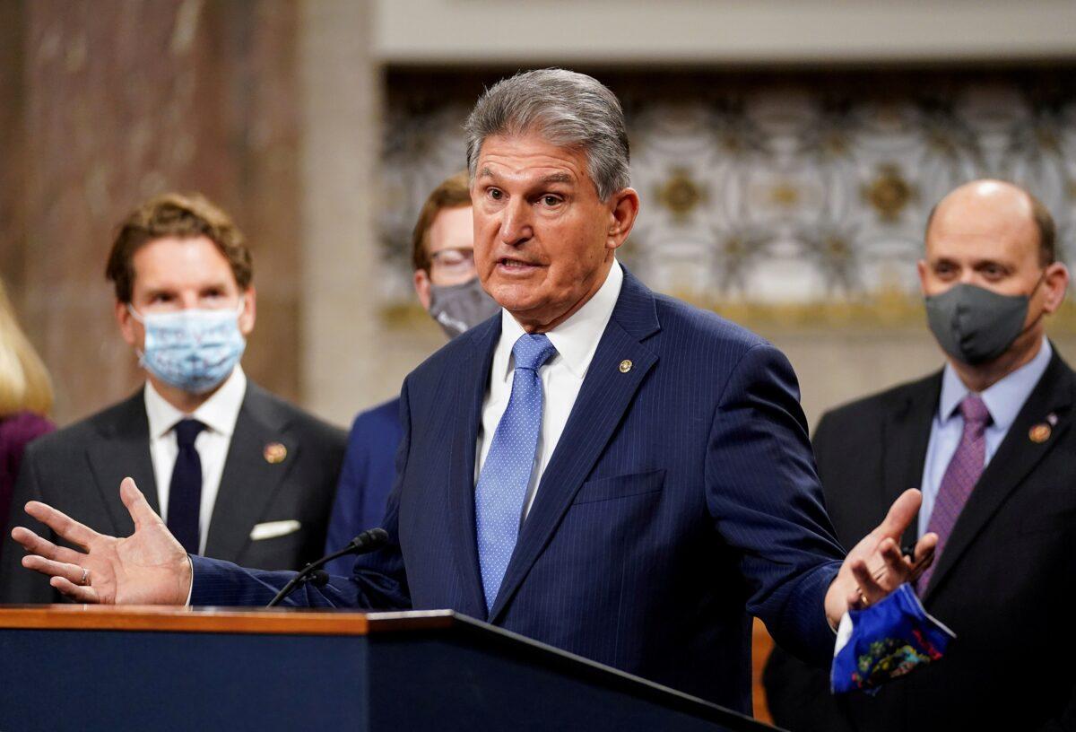 Sen. Joe Manchin (D-W.Va.) removes his mask to speak as bipartisan members of the Senate and House gather to announce a framework for new COVID-19 relief legislation at a news conference on Capitol Hill in Washington on Dec. 1, 2020. (Kevin Lamarque/Reuters)