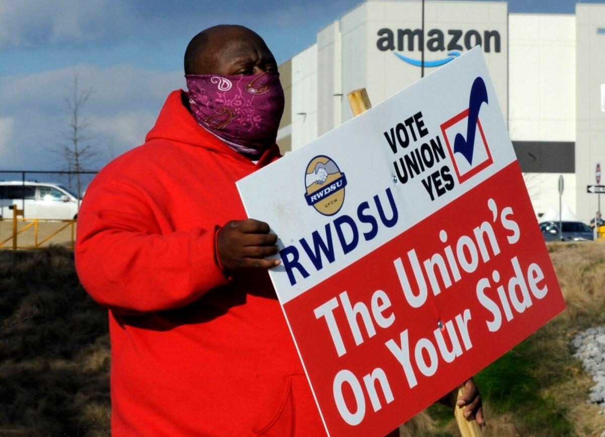 Michael Foster of the Retail, Wholesale, and Department Store Union holds a sign outside an Amazon facility where labor is trying to organize workers in Bessemer, Ala., on Feb. 9, 2021. (Jay Reeves/AP Photo)