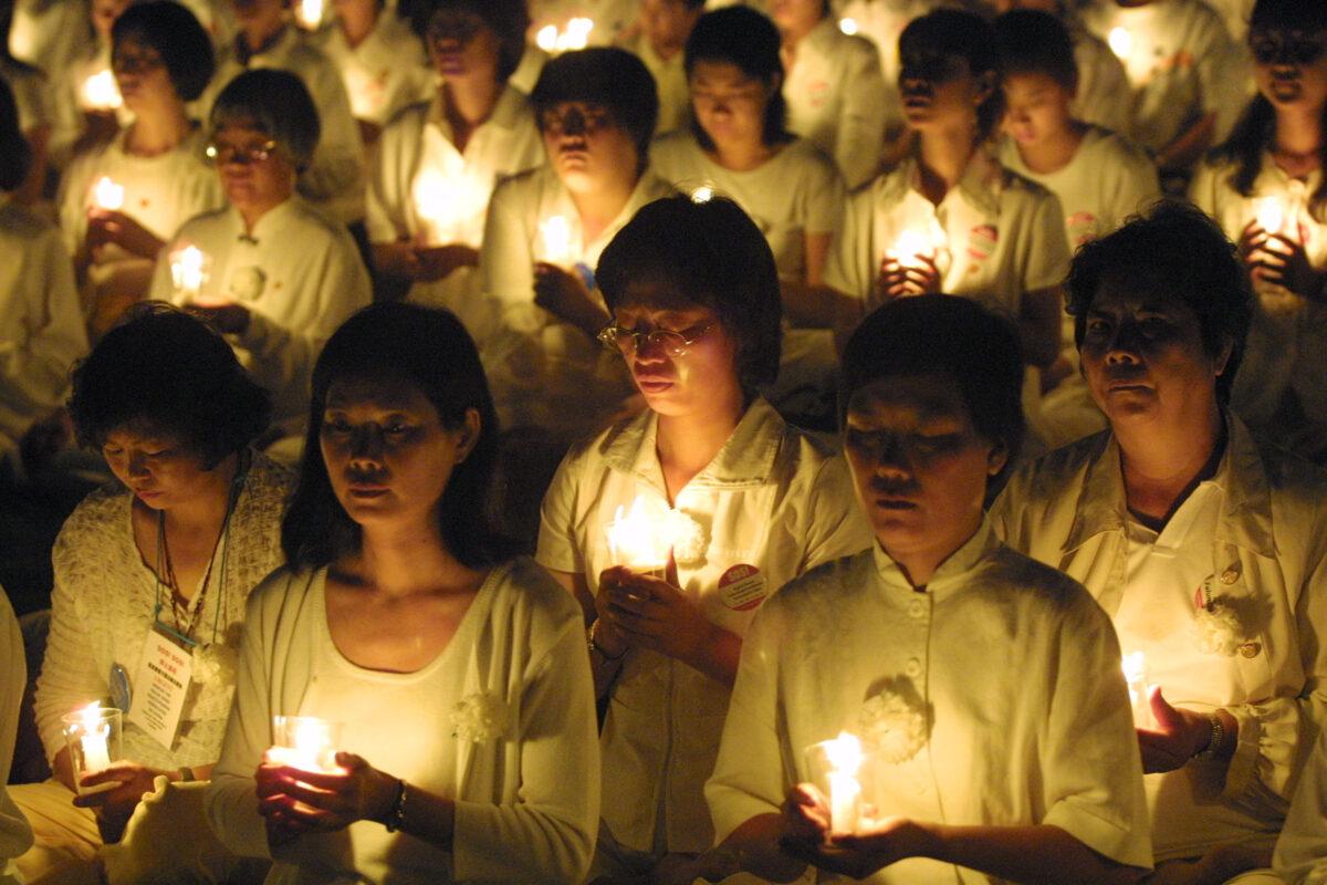 Falun Gong practitioners hold candles during a candlelight vigil to pay tribute to the lives of those in China who have been beaten and tortured to death, in Washington on July 19, 2001. (Alex Wong/Getty Images)