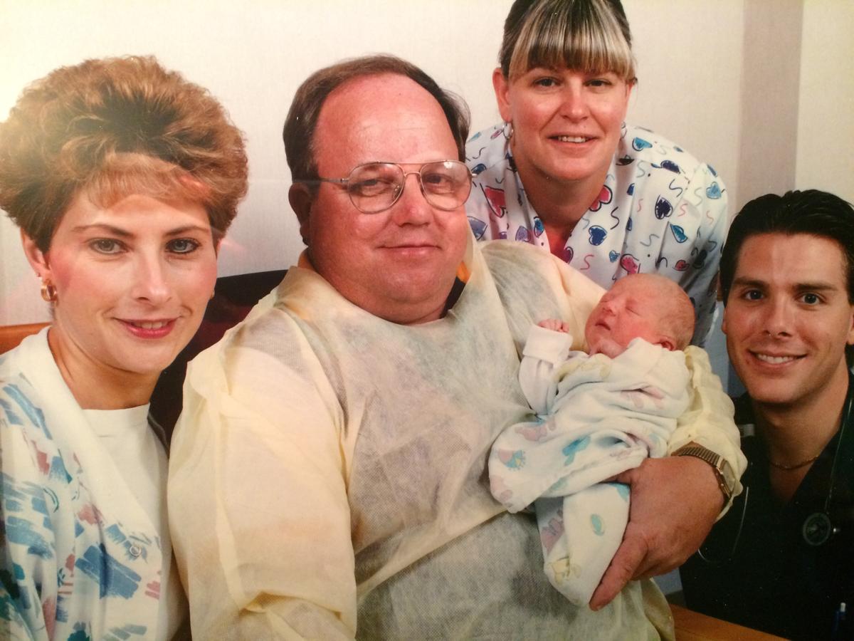 Baby Mary Grace with her rescuers, Garold "Rocky" Hyatt (C) and nurse Carol Szafranski (2nd-R), in October 1995. (Courtesy of <a href="https://thestoryofbabymarygrace.com/">Morgan Hill</a>)