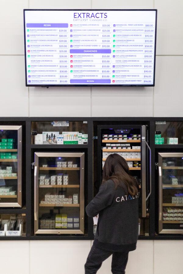 A Catalyst Cannabis employee organizes sales floor shelves in Santa Ana, Calif., on Feb. 18, 2021. (John Fredricks/The Epoch Times)