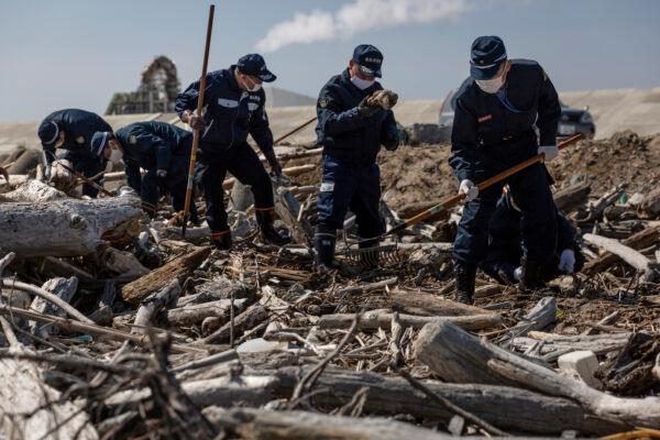 Police officers search for the remains of people who went missing after the March 2011 earthquake and tsunami in Namie, Japan. (Yuichi Yamazaki/Getty Images)