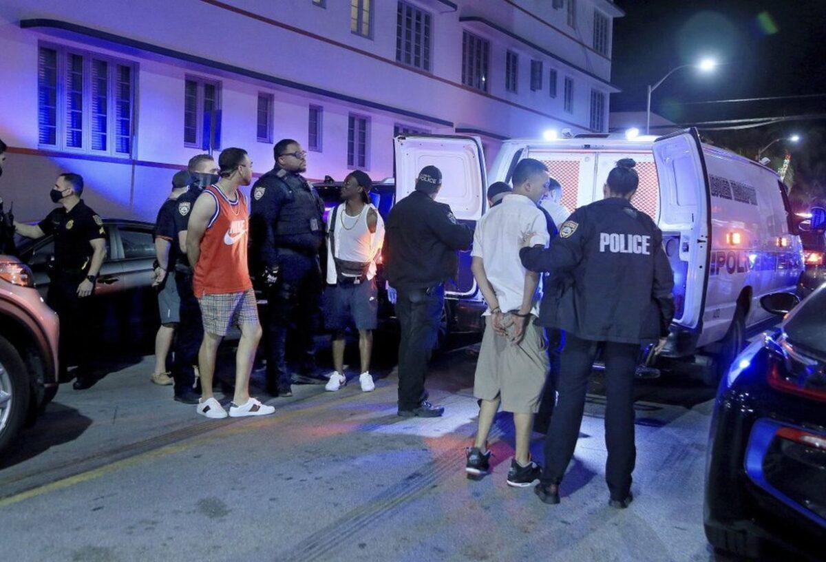 City of Miami Beach Police officers arrest several males on Ocean Drive and 10th Street as spring break officially begins in Miami Beach, Fla., on Feb. 20, 2021. (Pedro Portal/Miami Herald via AP)