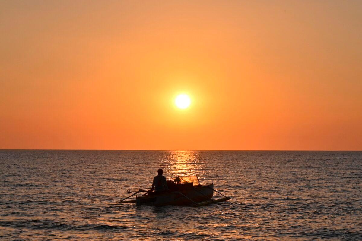 A Filipino fisherman sailing off at sunset from the coast of Bacnotan, La Union, Province, in northwestern Philippines facing the South China Sea on Feb. 14, 2020. (ROMEO GACAD/AFP via Getty Images)