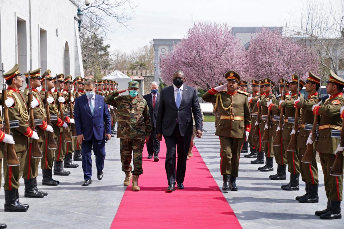 U.S. Defense Secretary Lloyd Austin (C) walks on the red carpet with Acting Afghan Minister of Defense Yasin Zia as they review an honor guard at the presidential palace in Kabul, Afghanistan, on March 21, 2021. (Presidential Palace via AP)