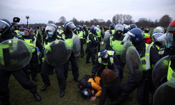 Police officers detain people during a protest against CCP virus lockdown in London, on March 20, 2021. (Henry Nicholls/Reuters)