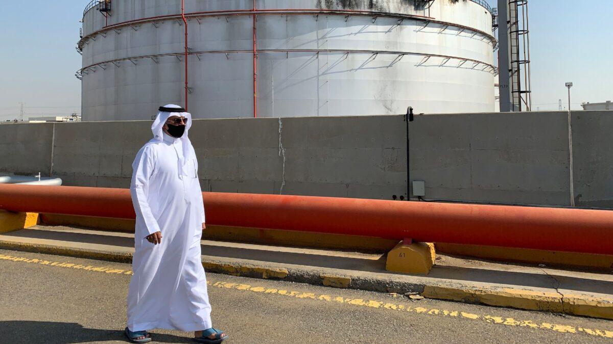 A man, mask-clad due to the COVID-19 coronavirus pandemic, walks past a damaged silo at the Saudi Aramco oil facility in Saudi Arabia's Red Sea city of Jeddah, on Nov. 24, 2020. (Fayez Nureldine/AFP via Getty Images)