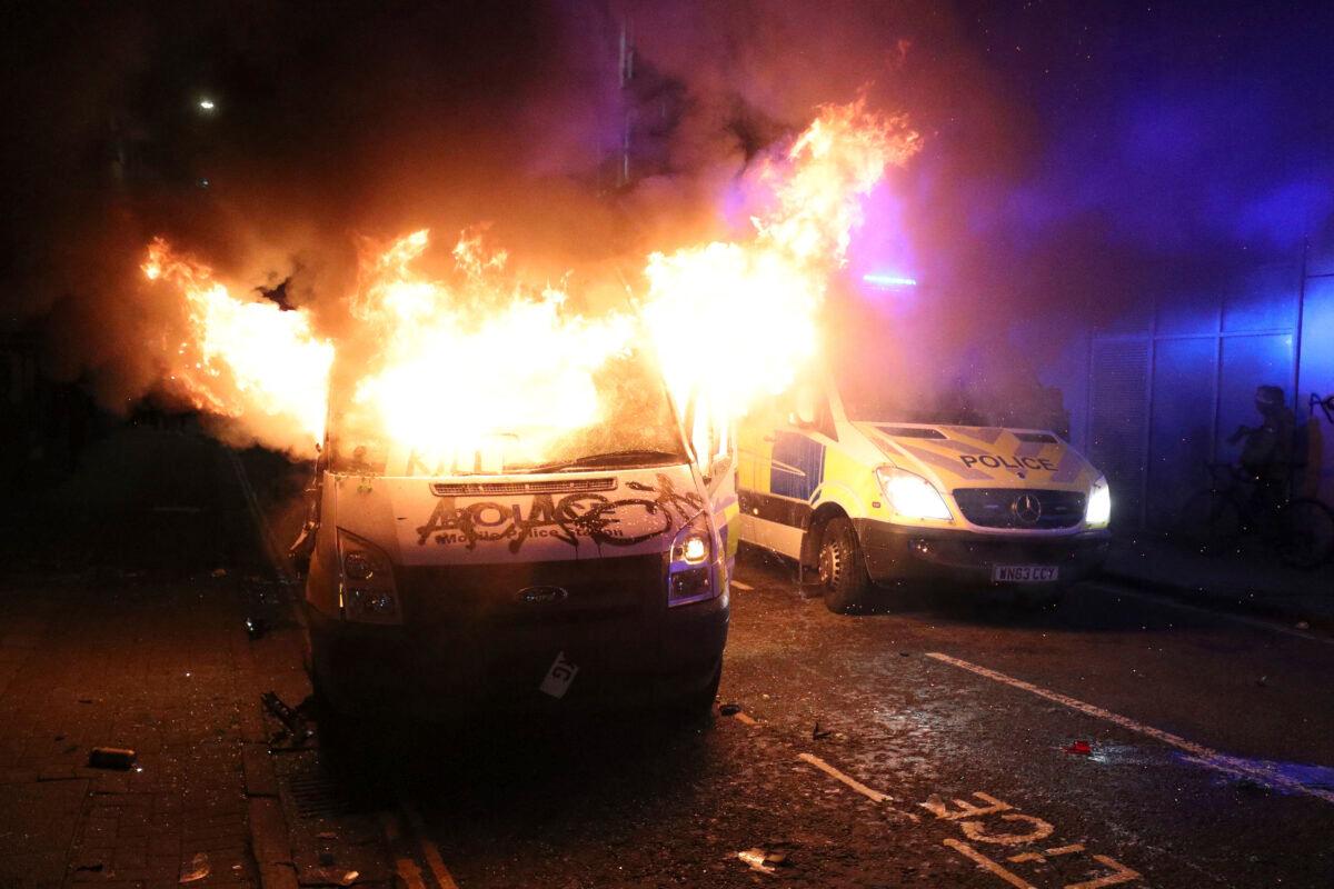 A vandalised police van on fire outside Bridewell Police Station as people took part in a protest demonstrating against the Police and Crime Bill, in Bristol, England, on Sunday, March 21, 2021. (Andrew Matthews/PA via AP)