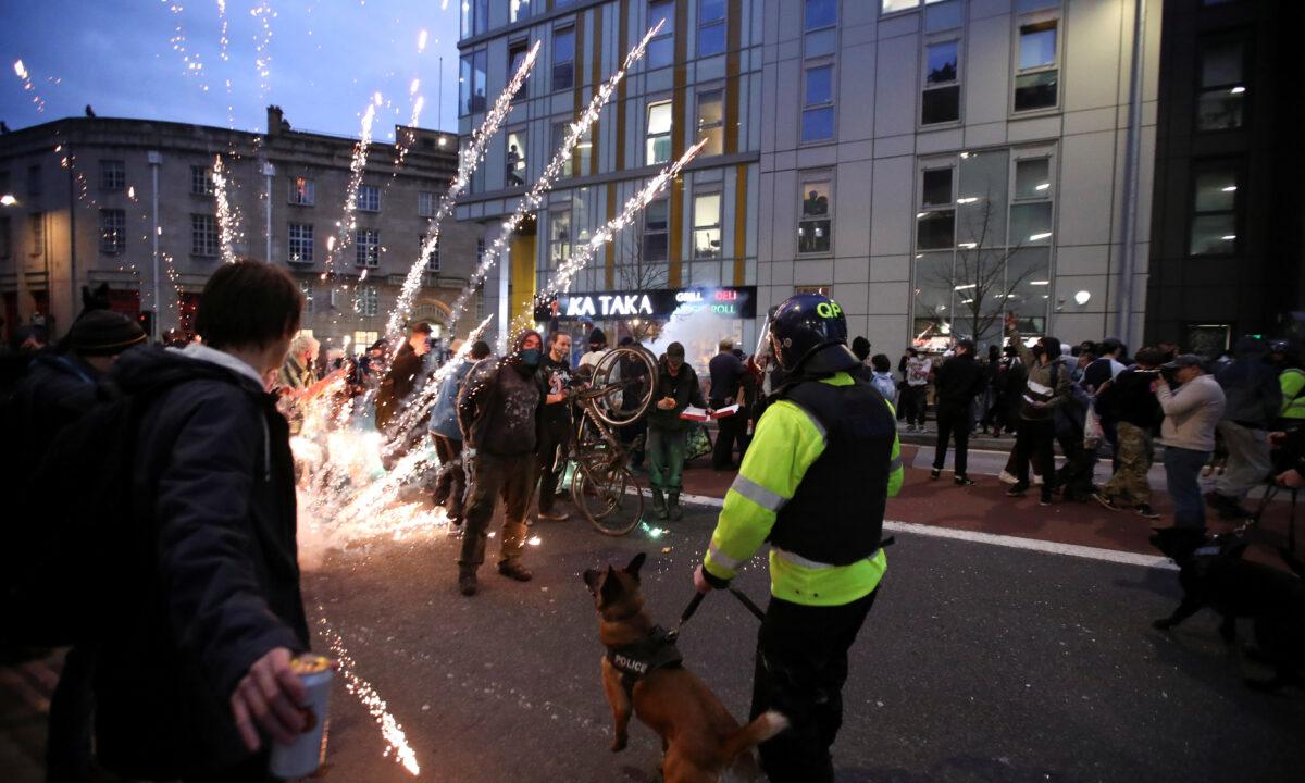 Fireworks are launched as police officers with dogs arrive to a protest against a new proposed policing bill, in Bristol, Britain, on March 21, 2021. (Peter Cziborra/Reuters)