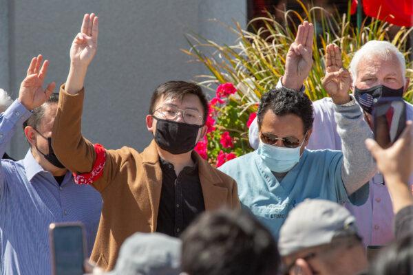 Thet Lin Tun, president of the Burmese Students Association at the University of California–Los Angeles, (L) holds up three fingers in a symbolic gesture of the pro-democracy movement at a rally in Stanton, Calif., on March 20, 2021. (John Fredricks/The Epoch Times)
