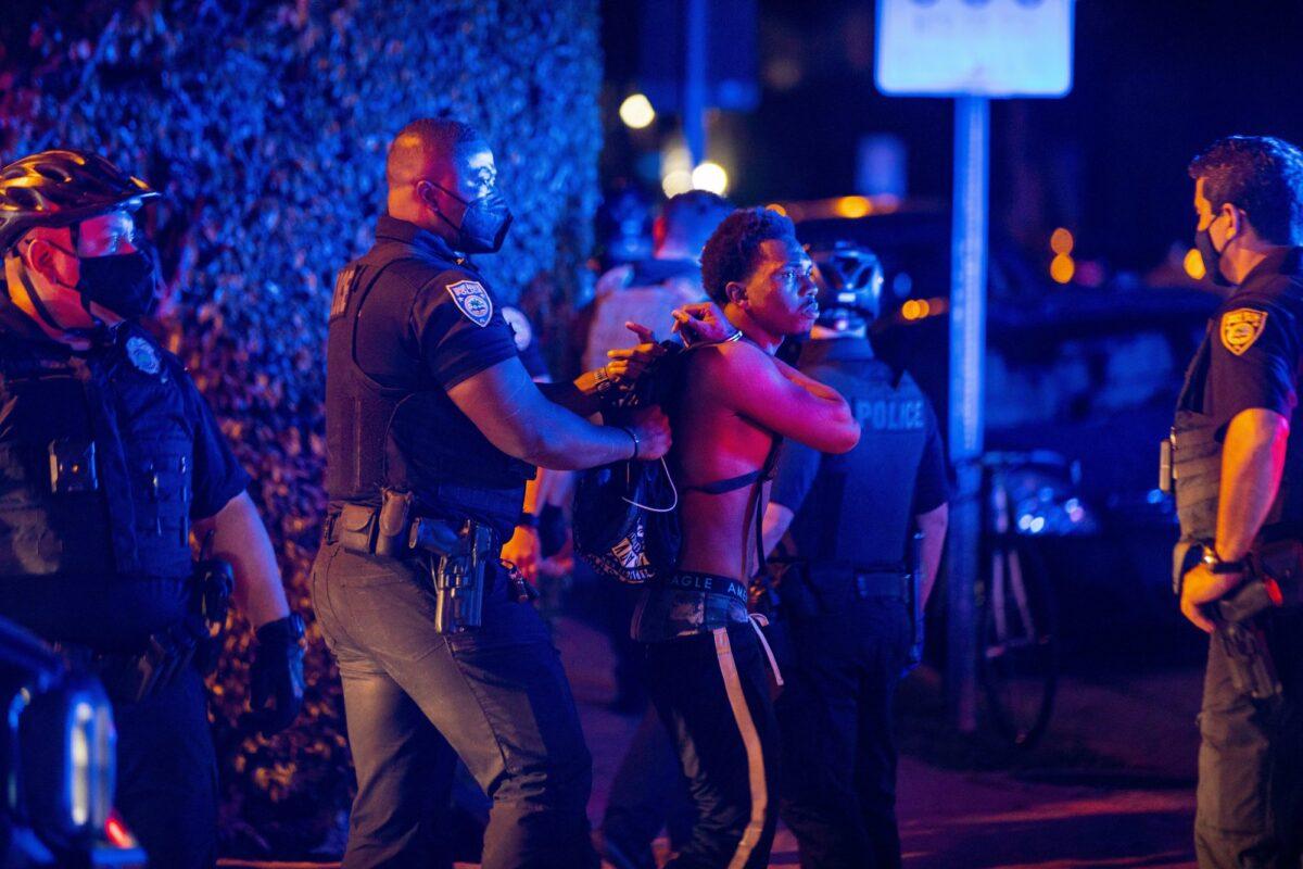 A man is arrested while out a few hours past curfew in Miami Beach, Fla., on March 21, 2021. (Daniel A. Varela/Miami Herald via AP)