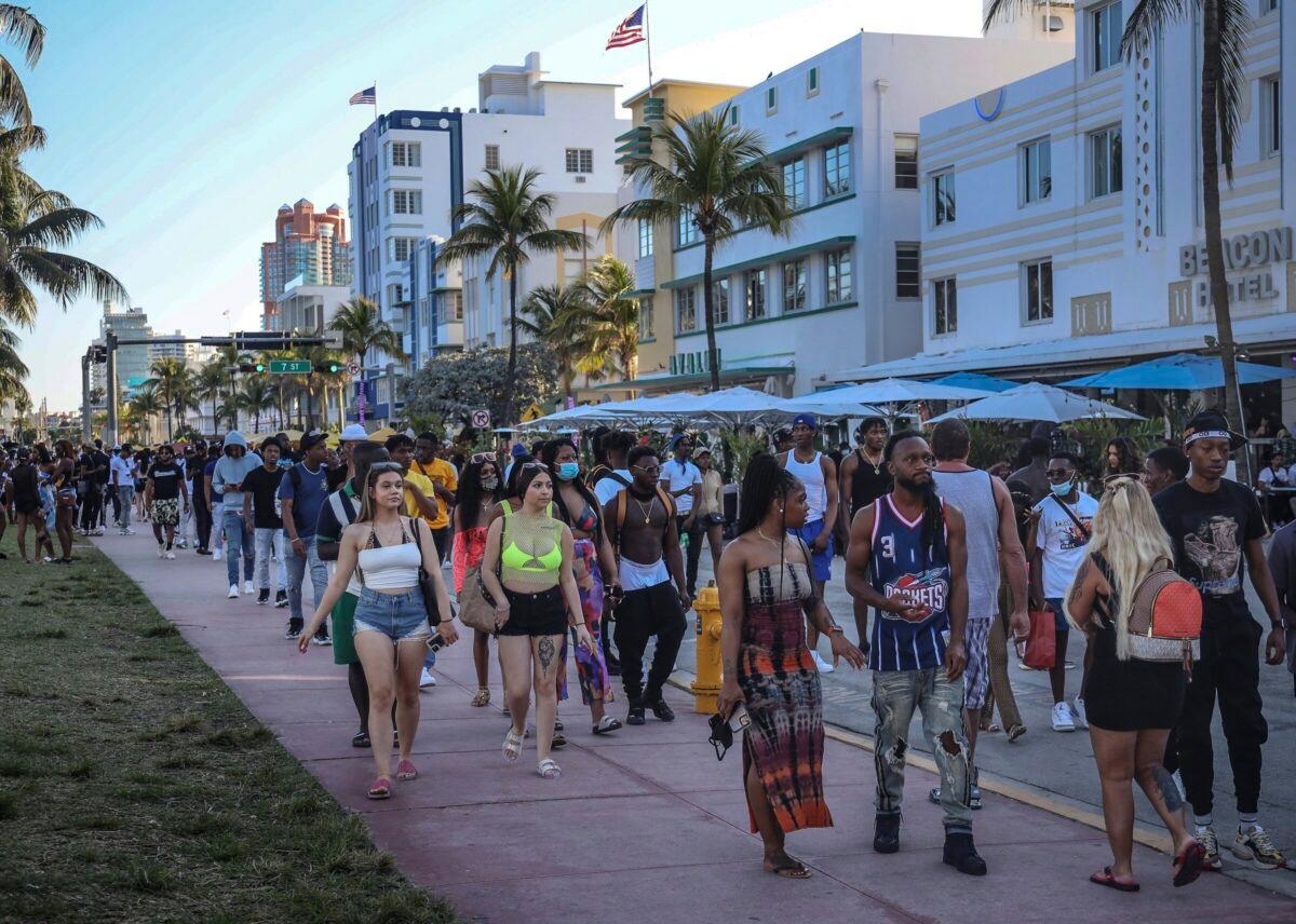 Spring break tourists walk alongside Ocean Drive in Miami Beach, Fla., on March 21, 2021. (Carl Juste/Miami Herald via AP)