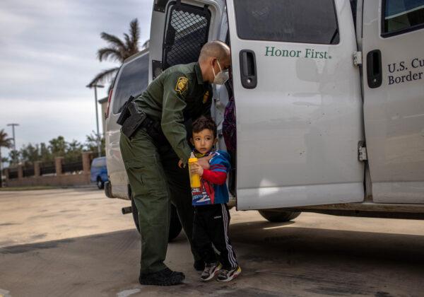 A Border Patrol agent delivers a family unit that entered the United States to a bus station in Brownsville, Texas on Feb. 26, 2021. (John Moore/Getty Images)