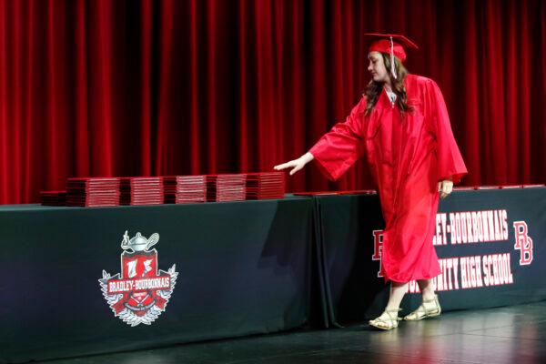 A student picks up her diploma during a graduation ceremony at Bradley-Bourbonnais Community High School on May 6, 2020, in Bradley, Ill. (KAMIL KRZACZYNSKI/AFP via Getty Images)