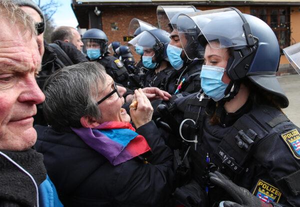 Police try to push back protesters who take part in a demonstration demanding an end to restrictive CCP virus measures in Kassel, Germany, on March 20, 2021. (Armando Babani/AFP via Getty Images)