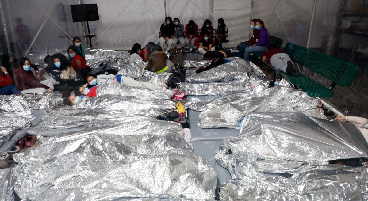 Unaccompanied minors sleep side by side on the floor at a temporary processing facility in Donna, Texas, on March 23, 2021. (CBP)