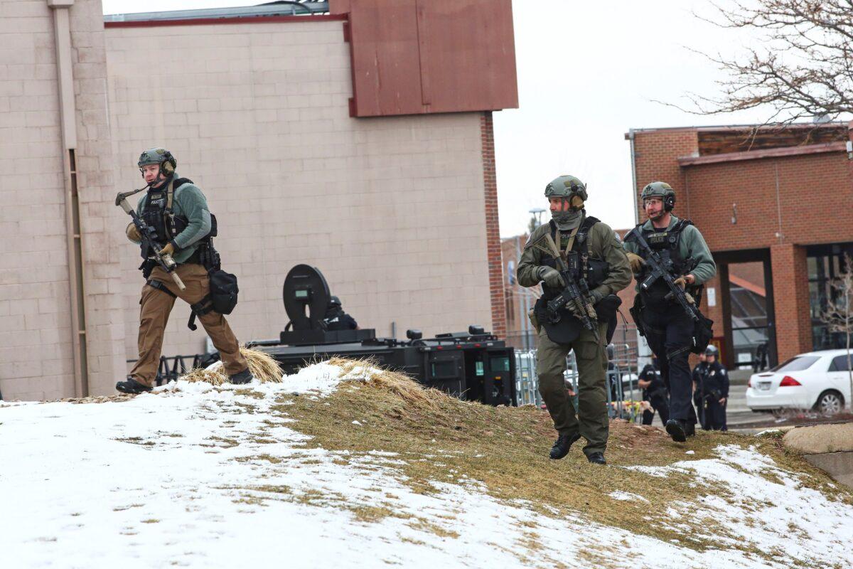 Law enforcement officers sweep the area outside of a King Soopers grocery store, which was the site of a shooting in Boulder, Colo., on March 22, 2021. (Kevin Mohatt/Reuters)