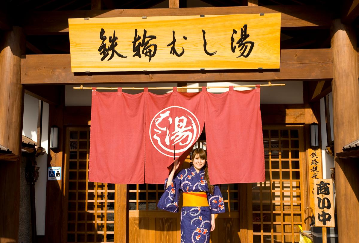A woman in traditional dress in front of the Kannawa Steam Bath in the city of Beppo, Japan. (Promotion Airport Environment Improvement Foundation/JNTO)