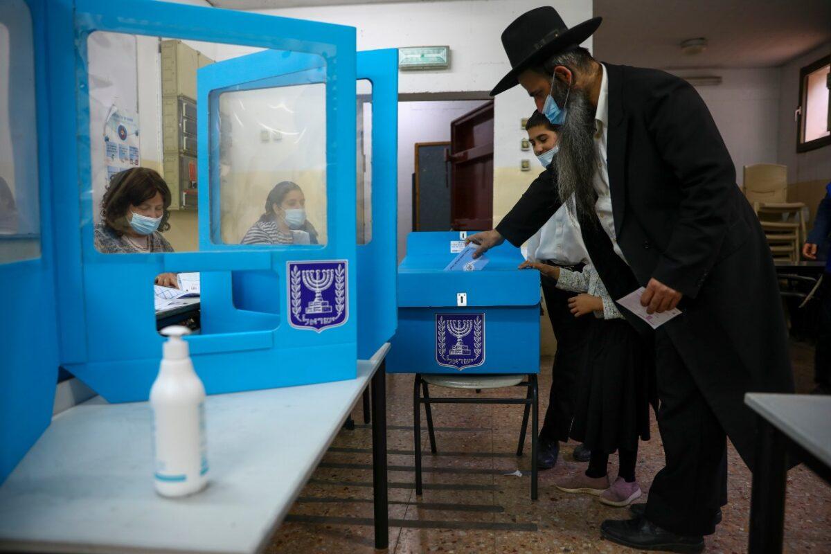 An Ultra-Orthodox Jewish man votes for Israel's parliamentary election at a polling station in Bnei Brak, Israel, on March 23, 2021. (Oded Balilty/AP Photo)