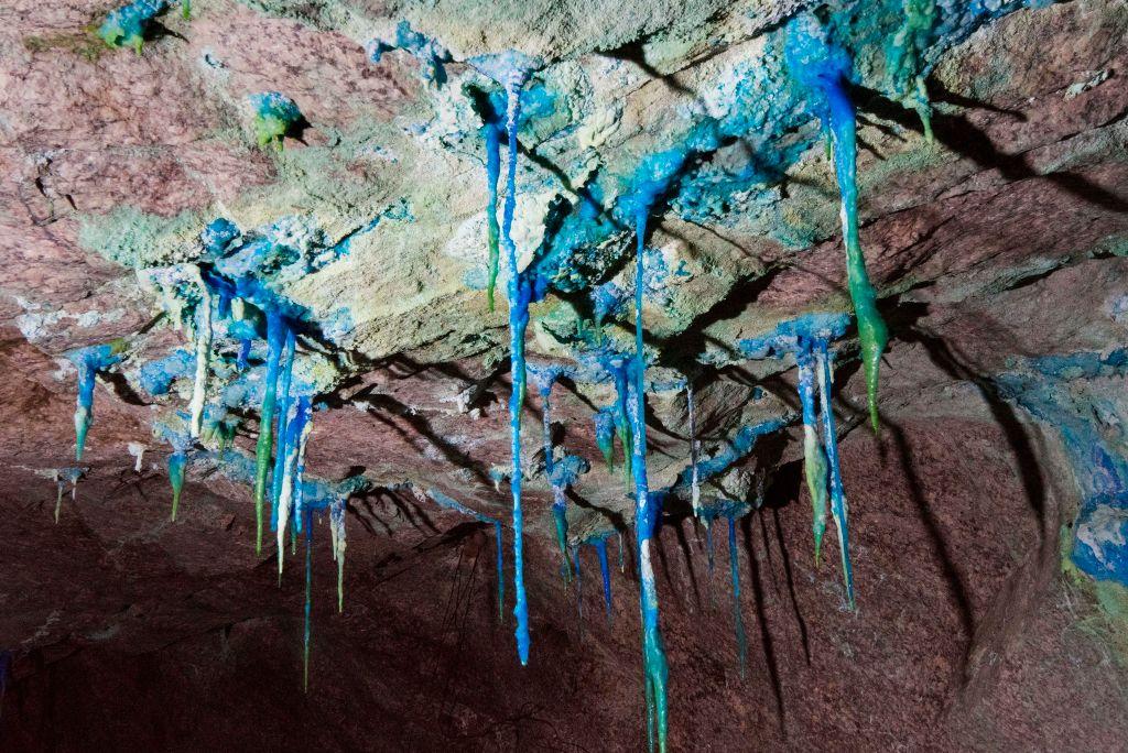 Stalactites containing copper hang downward from the ceiling of a tunnel at Steenkampskraal rare earth mine in South Africa on July 29, 2019, (Rodger Bosch/AFP via Getty Images)