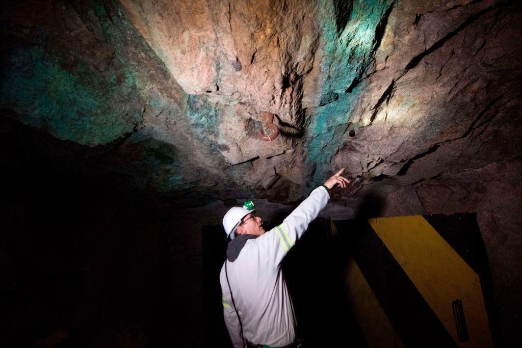 A mine geologist points to where the monazite reef (darker rock) containing the rare earth minerals is, underground at the SKK rare earth mine about 80Km from the Western Cape town of Vanrhynsdorp, South Africa, on July 29, 2019. SKK has been confirmed as one of the highest-grade deposits of rare earth minerals in the world. (Rodger Bosch/AFP via Getty Images)