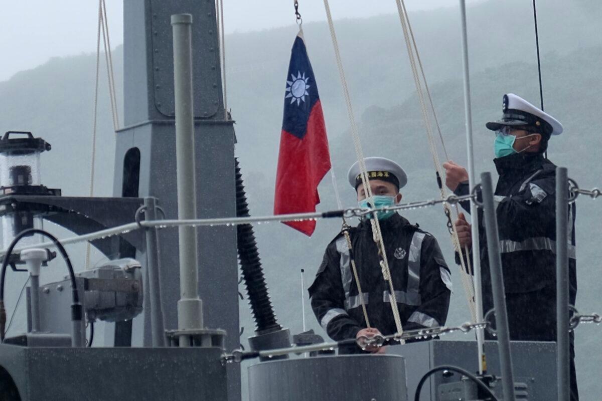 Two navy soldiers raise Taiwan's national flag during an official ceremony at a shipyard in Su'ao, a township in eastern Taiwan's Yilan County, on Dec. 15, 2020. (Sam Yeh/AFP via Getty Images)