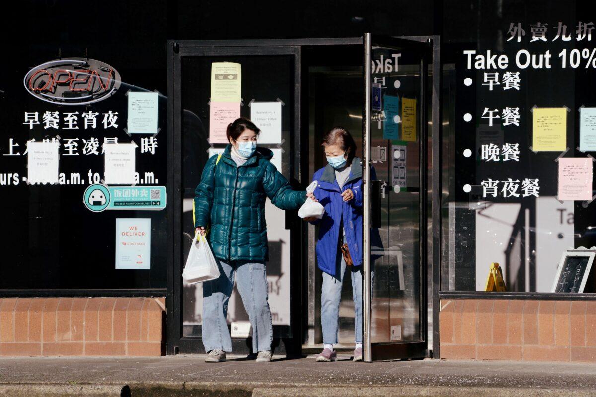 Two women exit the Enjoy Cafe 1 + 1, a popular Hong Kong-style eatery, in Richmond, British Columbia, on Jan. 26, 2021. (Reuters/Jennifer Gauthier/File Photo)