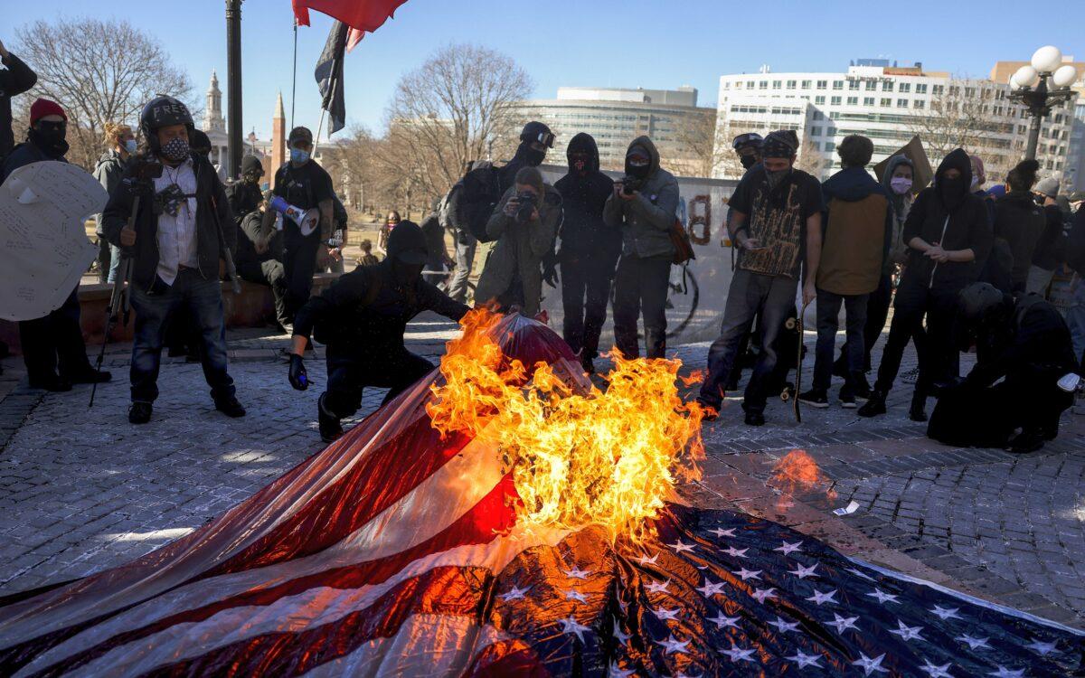 Members of the Communist Party USA and other anti-fascist groups burn an American flag on the steps of the Colorado State Capitol in Denver, Colo., on Jan. 20, 2021. (Michael Ciaglo/Getty Images)