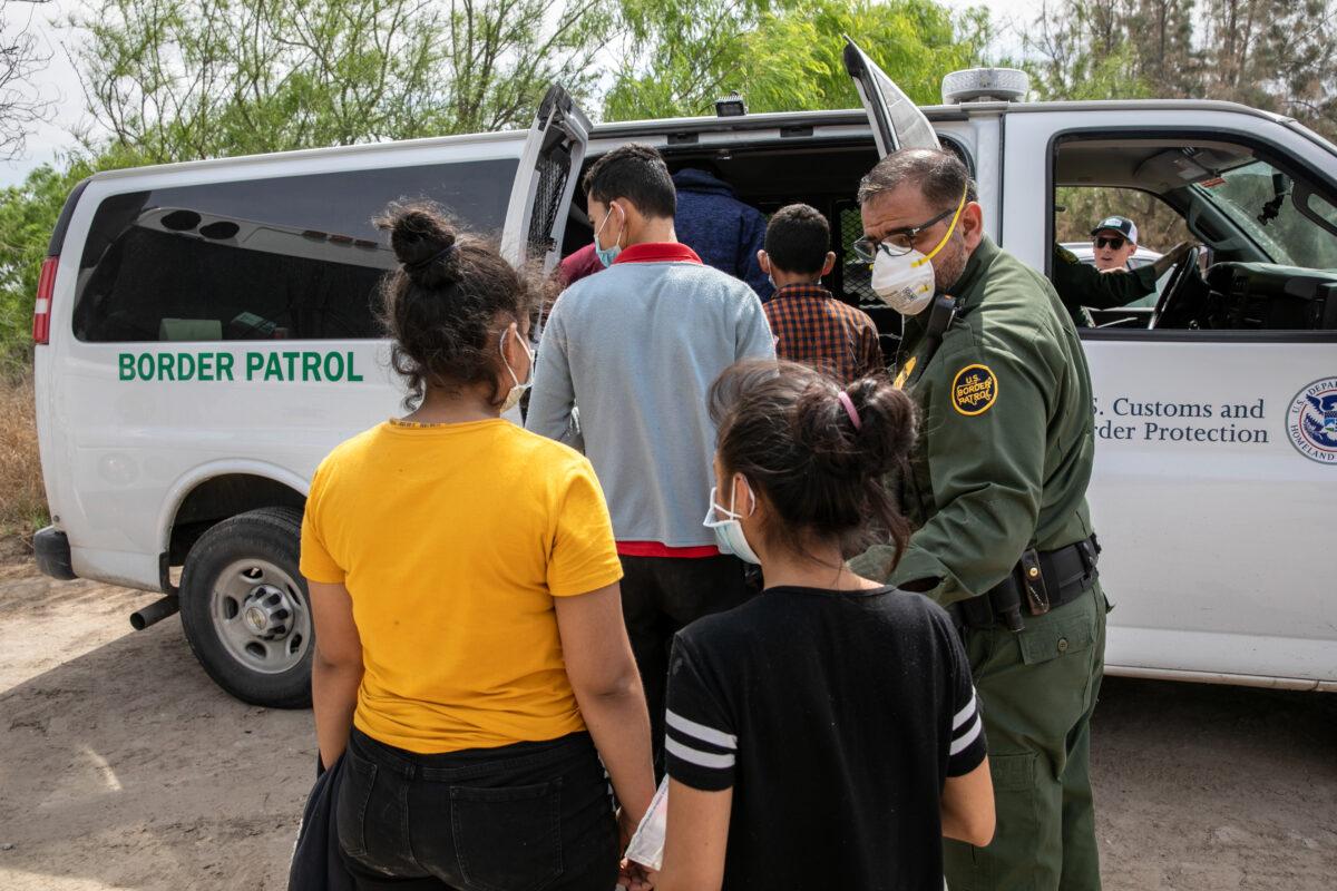 Unaccompanied minors are loaded into a U.S. Border Patrol transport van after crossing the U.S.–Mexico border, in Hildalgo, Texas, on March 25, 2021. (John Moore/Getty Images)