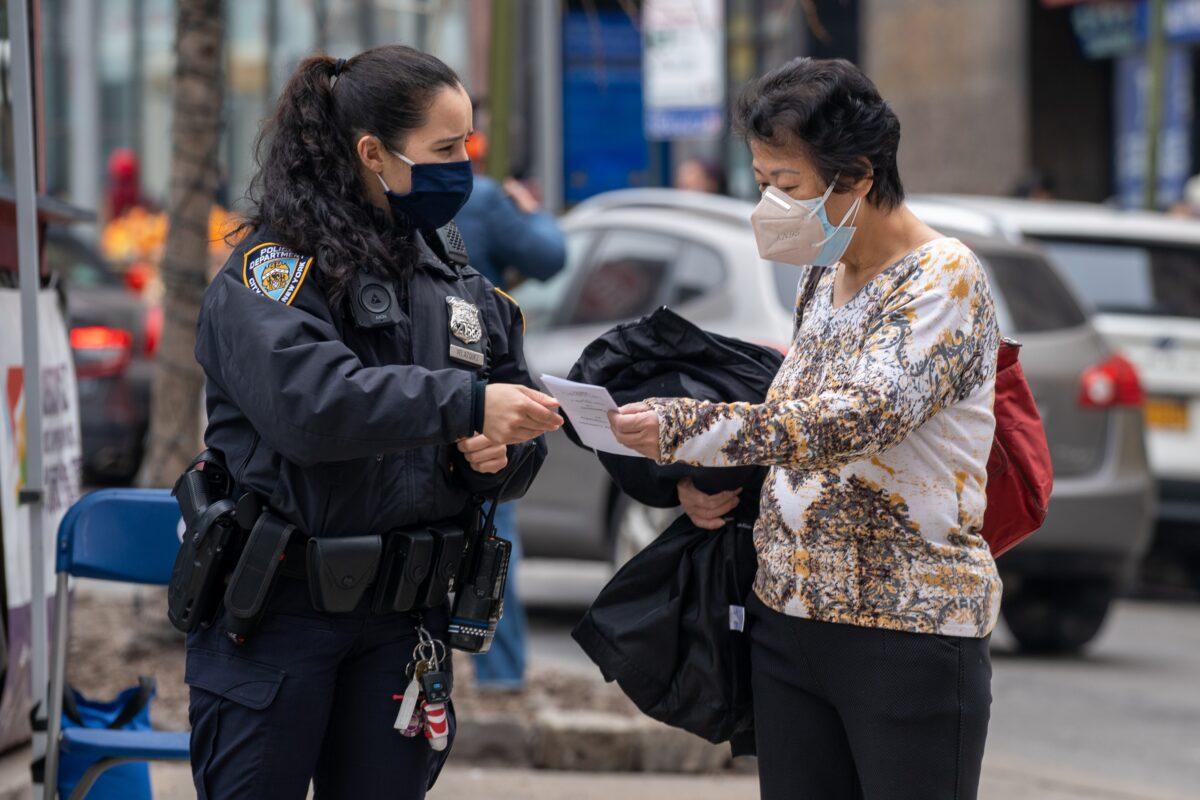 NYPD officers hand out information about hate crimes in Asian communities in New York City, on March 17, 2021. (David Dee Delgado/Getty Images)