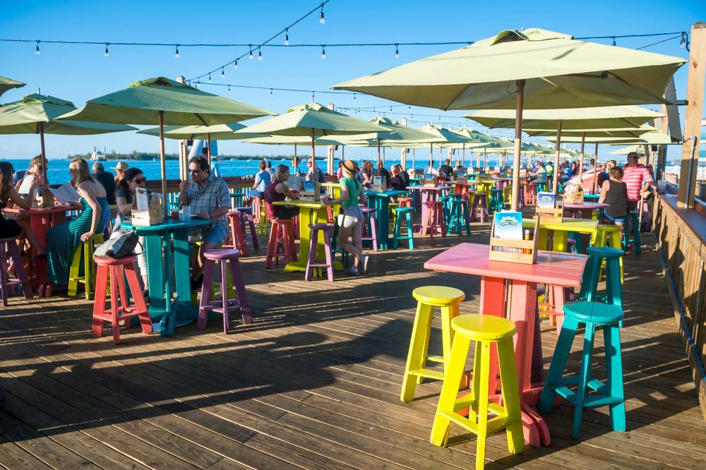 Visitors gather on colorful bar stools lining Sunset Pier at Mallory Square in Jan. 2019. (lazyllama/Shutterstock)