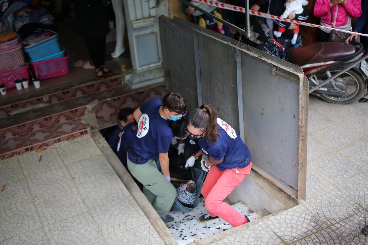 Four Paws rescuers lifting one of the bears out of the basement (Courtesy of Hoang Le/<a href="https://saddestbears.four-paws.us/">Four Paws</a>)