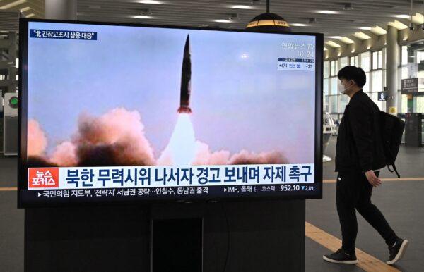 A man walks past a television screen at Suseo railway station in Seoul, showing news footage of North Korea's latest tactical guided projectile test, on March 26, 2021. (Jung Yeon-je/AFP via Getty Images)