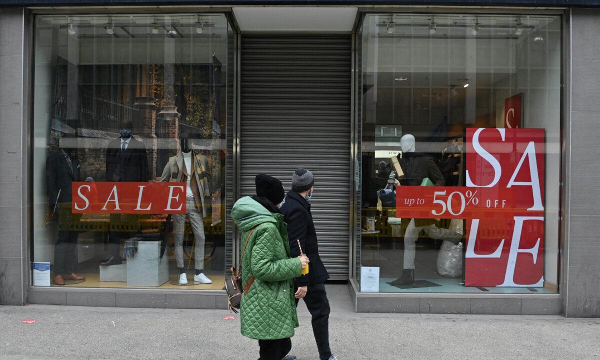 Pedestrians walk past a shuttered and closed-down branch of a Moss Bros clothes store on Oxford Street in central London on March 24, 2021. (Justin Tallis/AFP via Getty Images)