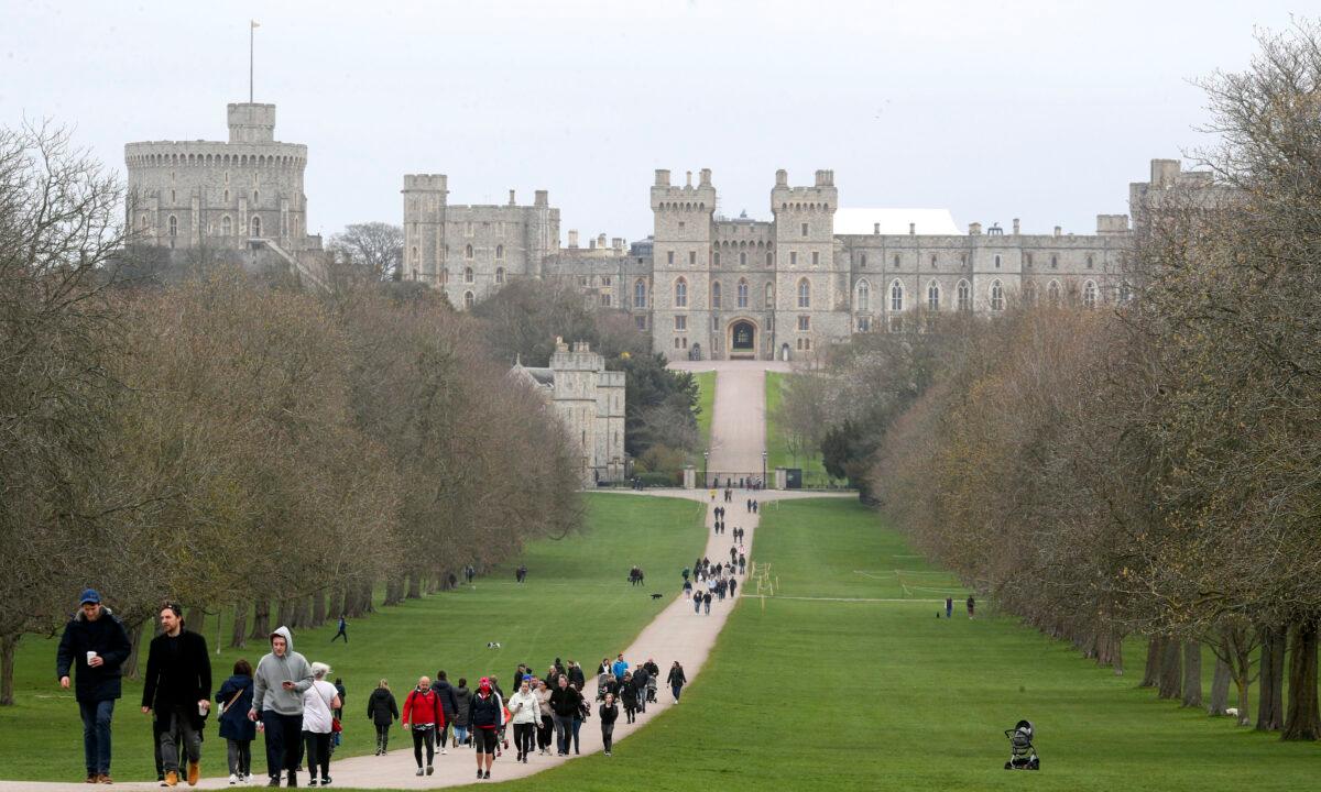 People walk along the Long Walk in Windsor, leading to Windsor Castle in the background, in England, on March 28, 2021. (Steve Parsons/PA via AP)