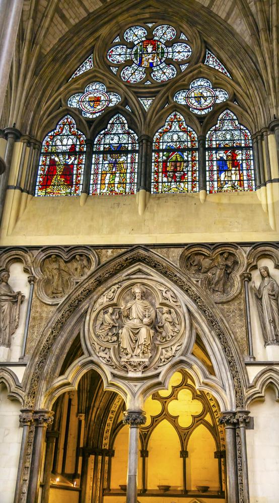 Christ flanked by angels is among some of the intricate sculptural reliefs in the 13th-century Chapter House. Kings and queens are honored in stained glass. (Bill Perry/Shutterstock.com)