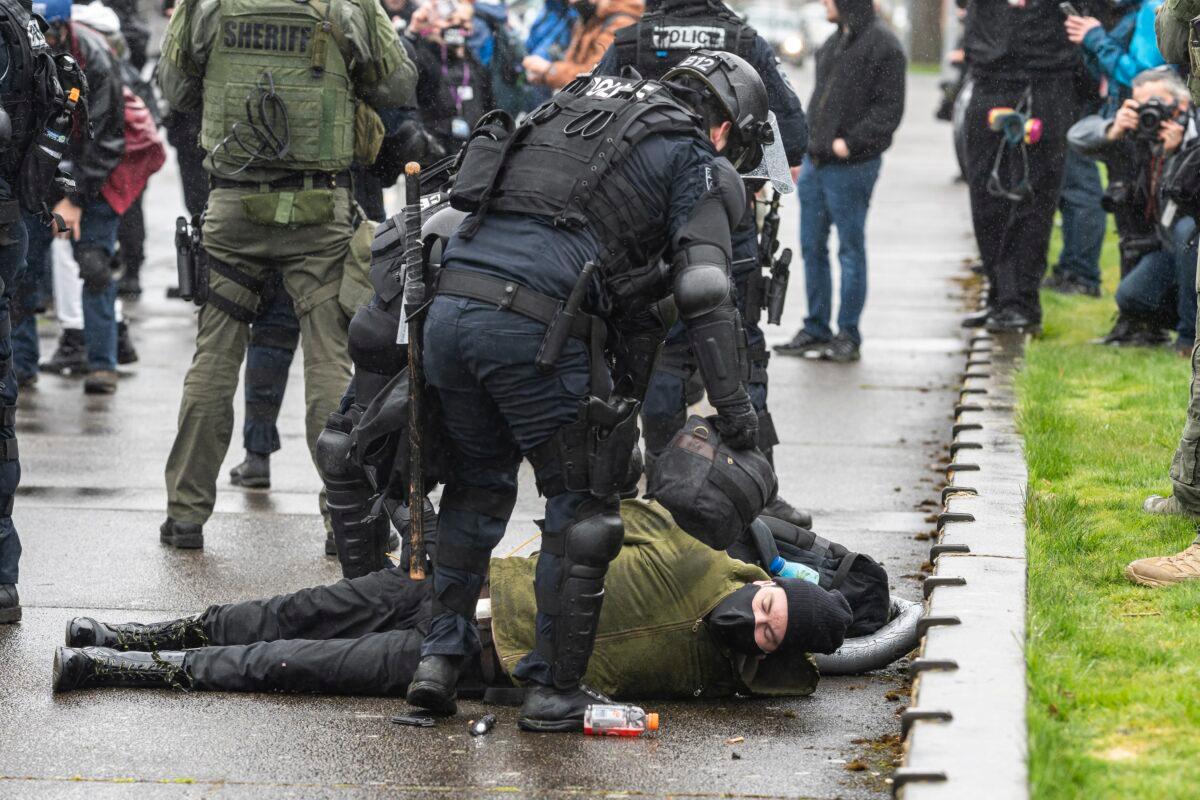 Law enforcement officers arrest a man during violent protests in Salem, Ore., on March 28, 2021. (Nathan Howard/Getty Images)