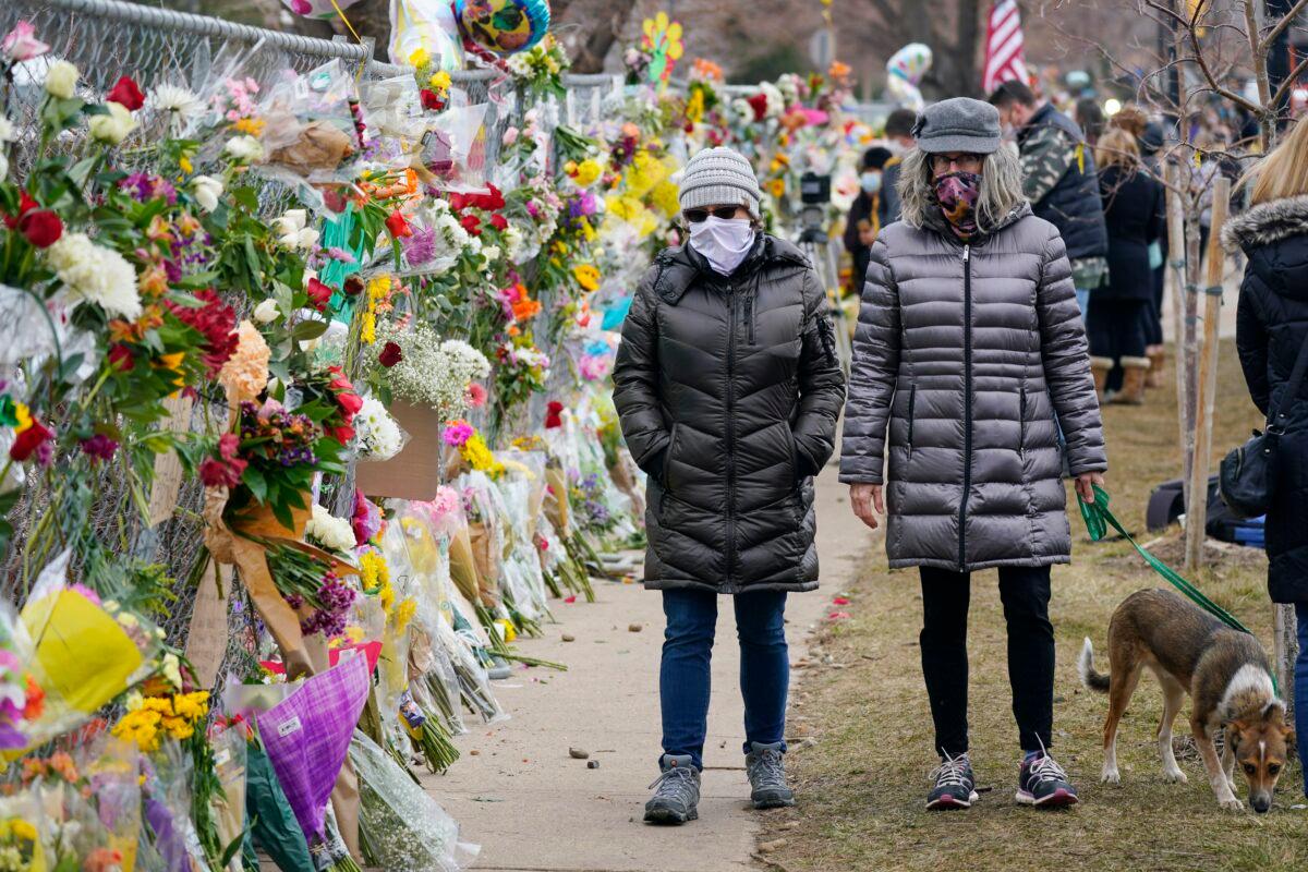 Mourners walk around a King Soopers grocery store, where 10 victims died in a mass shooting, in Boulder, Colo., on March 24, 2021. (AP Photo/David Zalubowski)